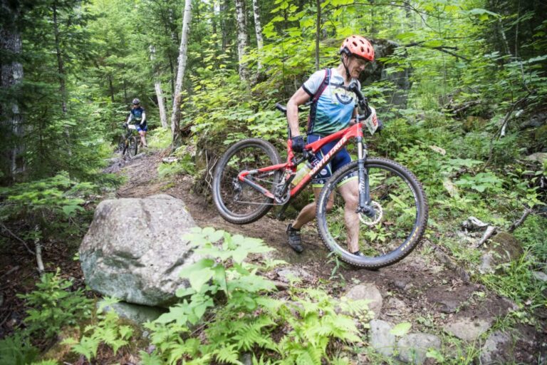 man having to carry bike down technical section