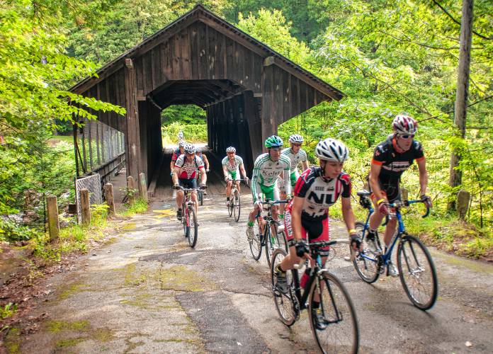 Riders crossing a classic covered bridge in New England