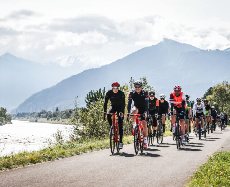 Pack of riders alongside Rhine river during Gran Fondo Vaduz