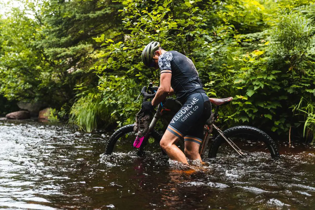 gravel cyclist in water at the crusher event