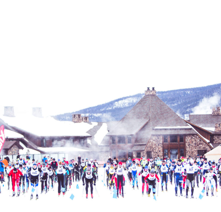 Eye view image from far distance of mass group of skiers gathering for the start of Stagecoach Classic in front of Devil's Thumb Classic Ranch and Spa